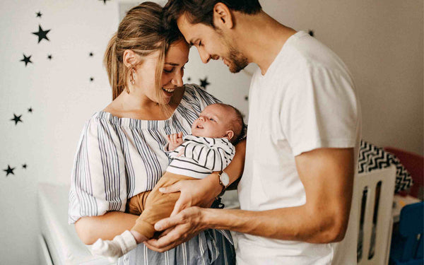 new parents holding new baby 